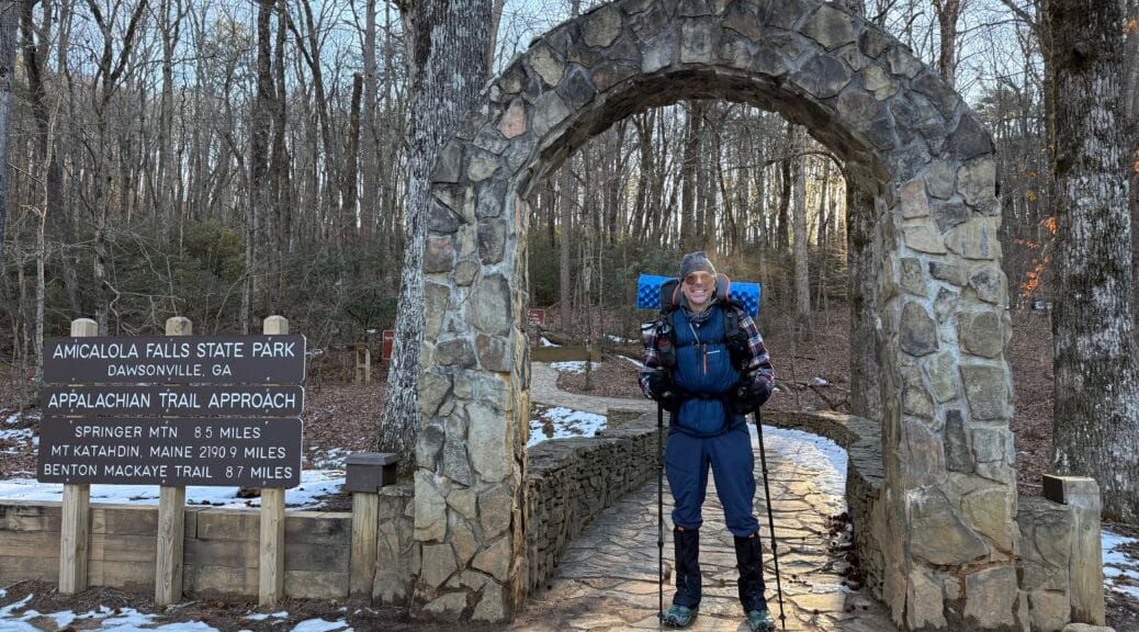 Benj poses under the arch at Amicalola Falls visitor center, the start of the AT approach trail.